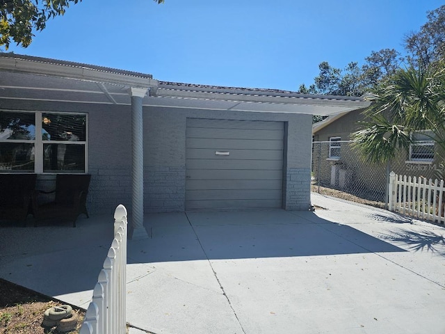 garage with fence and driveway