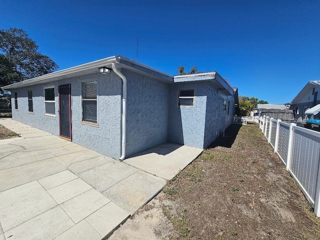 view of property exterior with fence and stucco siding