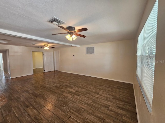 spare room featuring a ceiling fan, dark wood-style floors, and visible vents