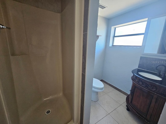 full bathroom featuring vanity, baseboards, a stall shower, tile patterned flooring, and toilet