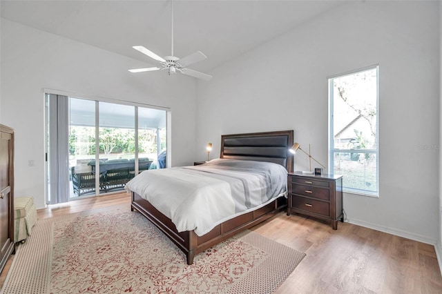 bedroom featuring access to exterior, light wood finished floors, baseboards, lofted ceiling, and a ceiling fan