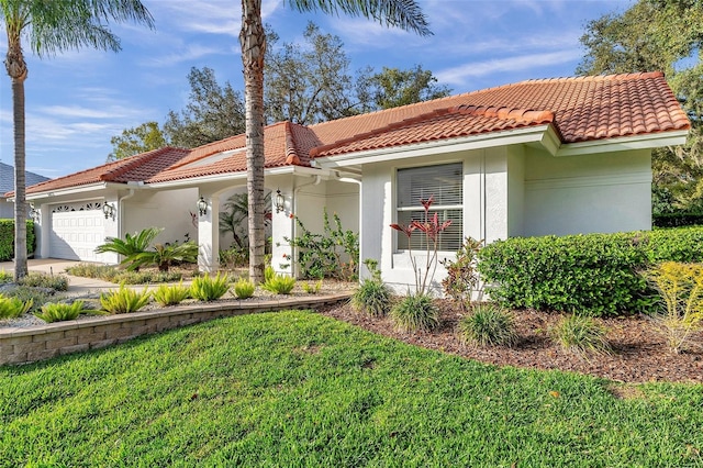 view of front of home with stucco siding, a tiled roof, an attached garage, and a front yard