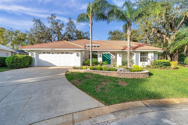 mediterranean / spanish-style house with a front lawn, a tiled roof, stucco siding, a garage, and driveway