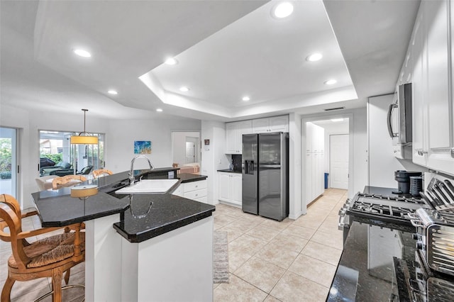 kitchen with a sink, recessed lighting, stainless steel appliances, white cabinets, and a raised ceiling