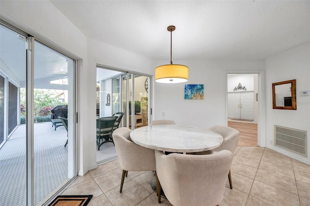 dining area with light tile patterned floors and visible vents