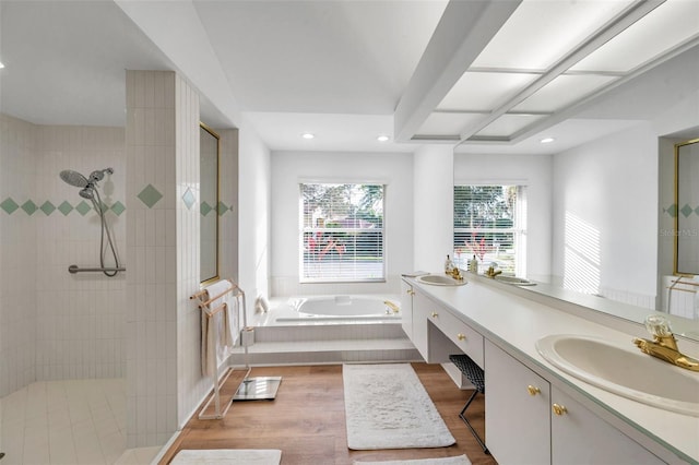 bathroom featuring walk in shower, a garden tub, recessed lighting, wood finished floors, and vanity