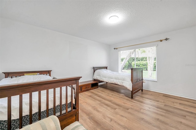 bedroom featuring a textured ceiling and light wood-style floors