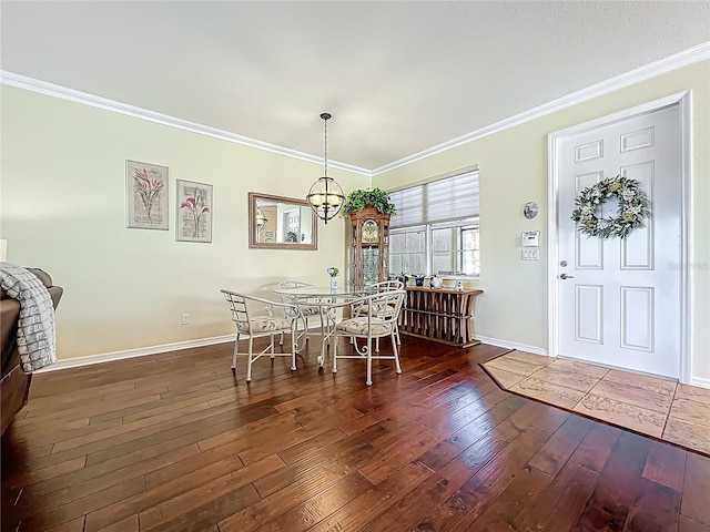 dining space featuring hardwood / wood-style floors, baseboards, and ornamental molding