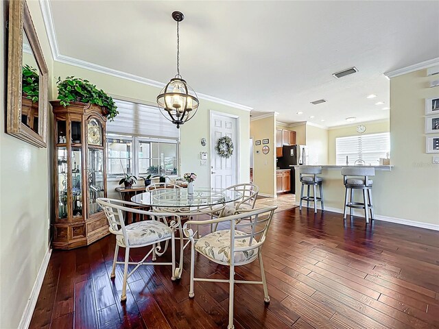 dining space with visible vents, baseboards, hardwood / wood-style floors, and ornamental molding