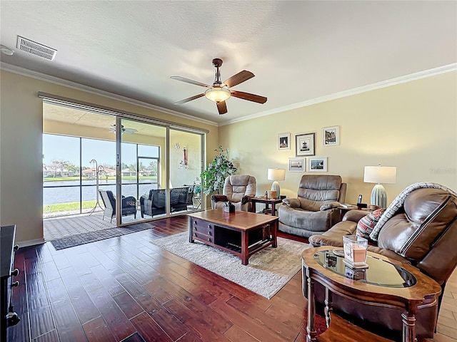 living area featuring dark wood-type flooring, crown molding, visible vents, and ceiling fan