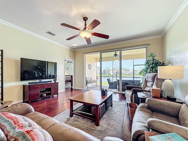 living area featuring visible vents, crown molding, baseboards, and wood finished floors