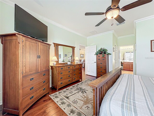 bedroom featuring visible vents, crown molding, ceiling fan, ensuite bathroom, and dark wood-style floors