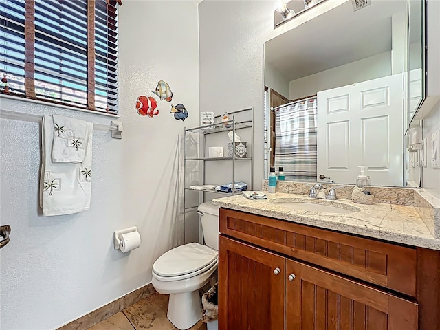 full bath featuring vanity, toilet, visible vents, and baseboards