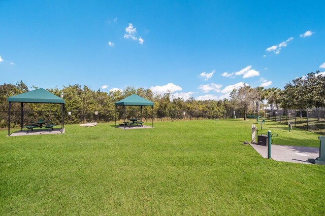 view of property's community featuring a lawn and fence