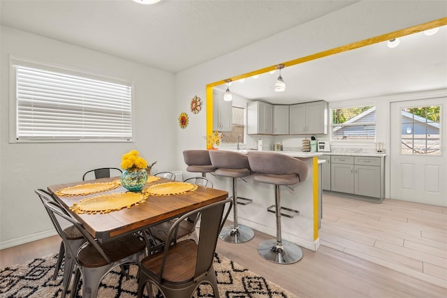 dining area with light wood-style floors and baseboards