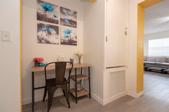 office with wood finished floors, visible vents, and baseboards