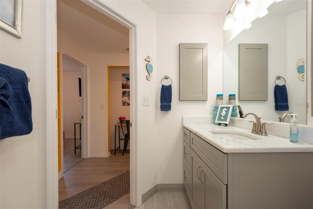 bathroom with vanity, baseboards, and wood finished floors