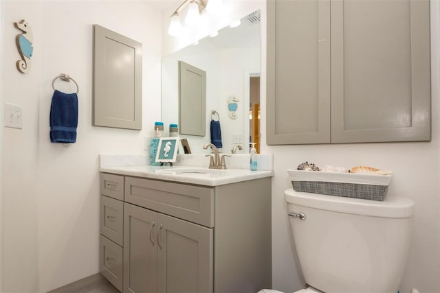 bathroom featuring visible vents, toilet, and vanity