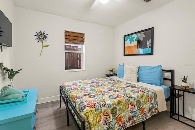 bedroom featuring a ceiling fan, baseboards, and wood finished floors