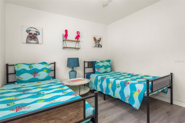 bedroom featuring baseboards and wood finished floors