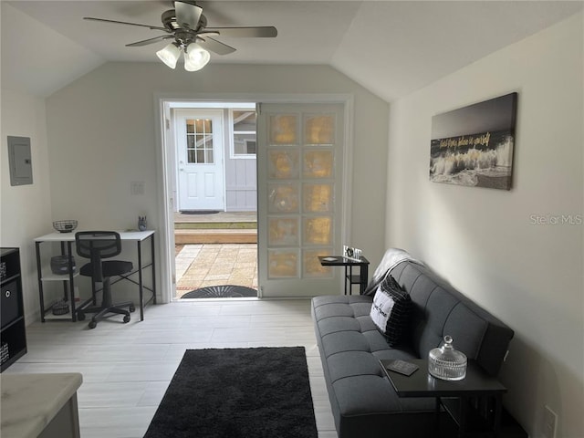 living area with electric panel, ceiling fan, and vaulted ceiling