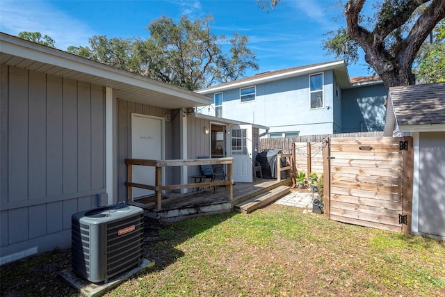 view of yard with cooling unit, fence, and a wooden deck