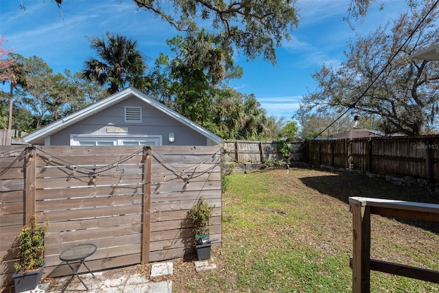 view of yard with a storage unit, an outdoor structure, and a fenced backyard