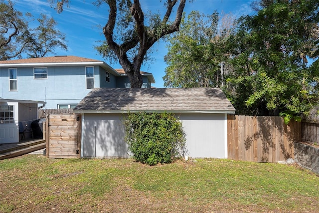 back of house with a lawn and fence