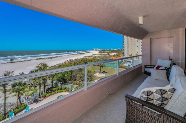 balcony featuring a beach view and a water view