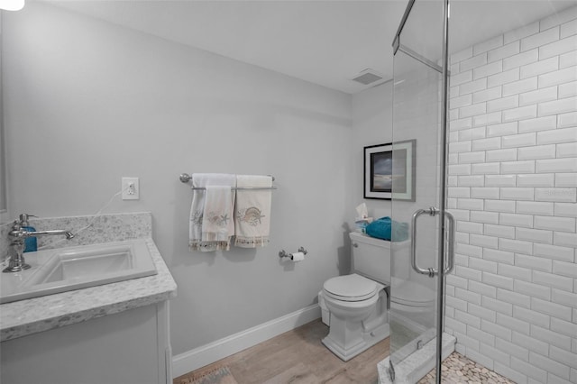 full bath featuring toilet, wood finished floors, vanity, visible vents, and a stall shower