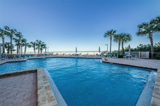 pool with a patio and fence