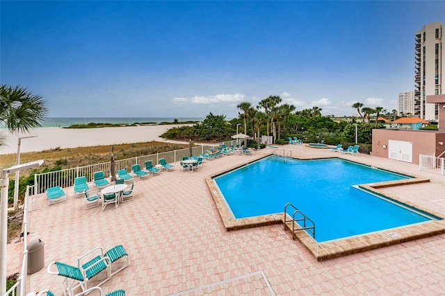 community pool featuring a patio area, a hot tub, and fence