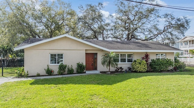 ranch-style house featuring a front yard, fence, and stucco siding