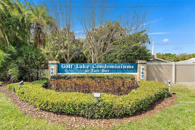 community / neighborhood sign featuring fence