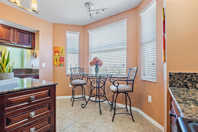 dining space with light tile patterned flooring and baseboards