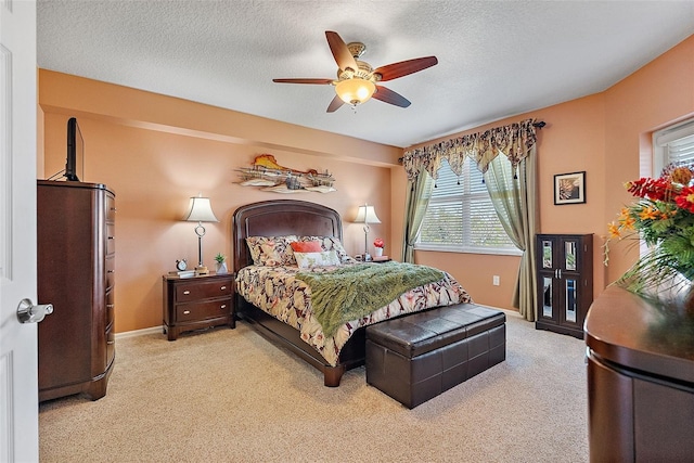 carpeted bedroom featuring baseboards, a textured ceiling, and ceiling fan