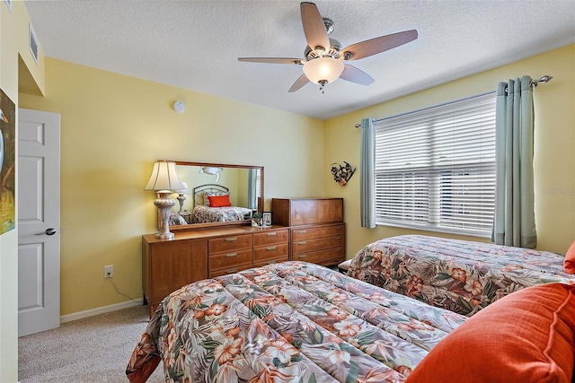 bedroom featuring visible vents, a ceiling fan, a textured ceiling, carpet, and baseboards