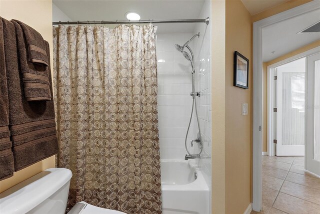 bathroom featuring tile patterned floors, visible vents, toilet, shower / tub combo with curtain, and baseboards