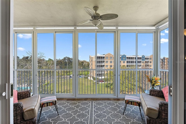 unfurnished sunroom with ceiling fan