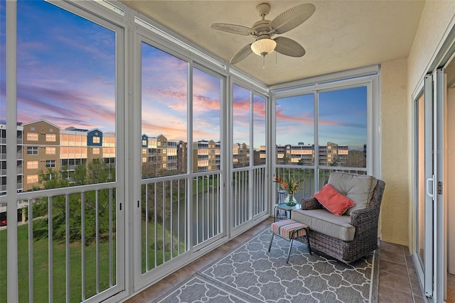 sunroom / solarium featuring a view of city and a ceiling fan