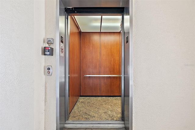 room details featuring elevator and a textured wall