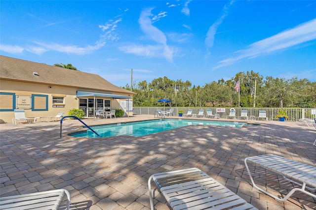 pool with a patio area and fence