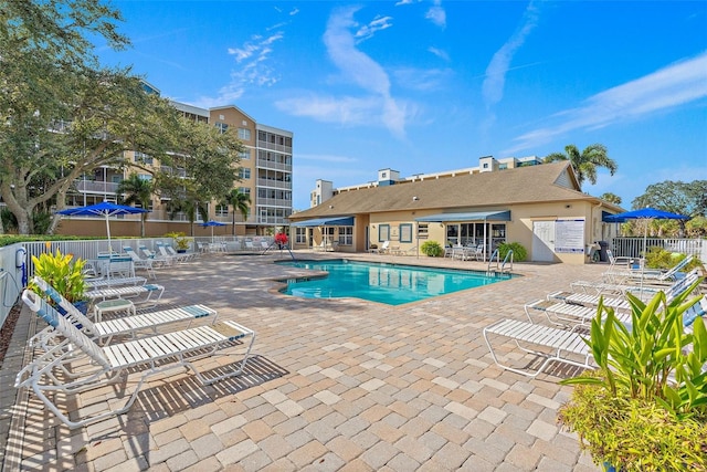 community pool with fence and a patio area