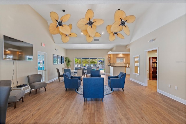 living area featuring light wood finished floors, visible vents, a ceiling fan, and baseboards