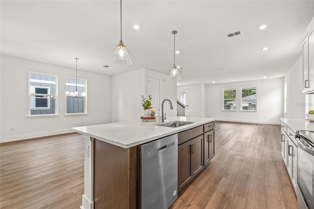 408 W Paris St, Tampa, FL 33604 - kitchen with stainless steel appliances, open floor plan, light wood finished floors, a kitchen island with sink, and recessed lighting