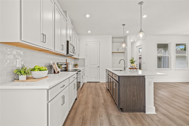 408 W Paris St, Tampa, FL 33604 - kitchen featuring appliances with stainless steel finishes, light wood-style floors, tasteful backsplash, recessed lighting, and light countertops
