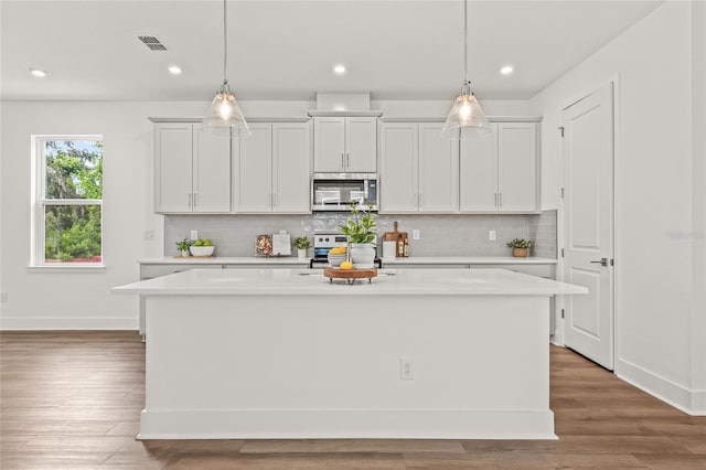 408 W Paris St, Tampa, FL 33604 - kitchen with appliances with stainless steel finishes, a kitchen island, light countertops, backsplash, and recessed lighting
