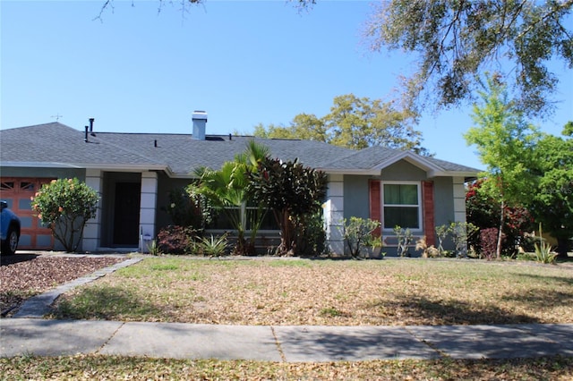 single story home with stucco siding, a chimney, a front yard, and a shingled roof