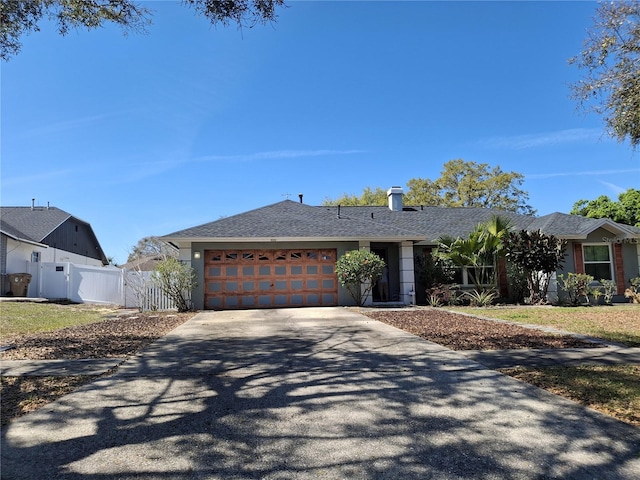 view of front of home featuring a garage, driveway, a shingled roof, a gate, and fence