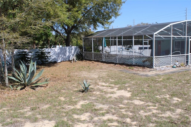 view of yard with a lanai and fence